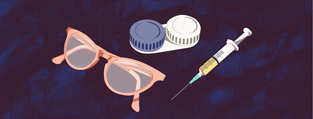 A pair of cat-eye glasses, a contact lenses case, and a syringe are all shown together.