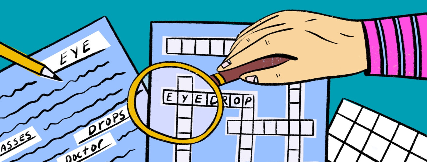 Hand holds a magnifying glass over a word puzzle