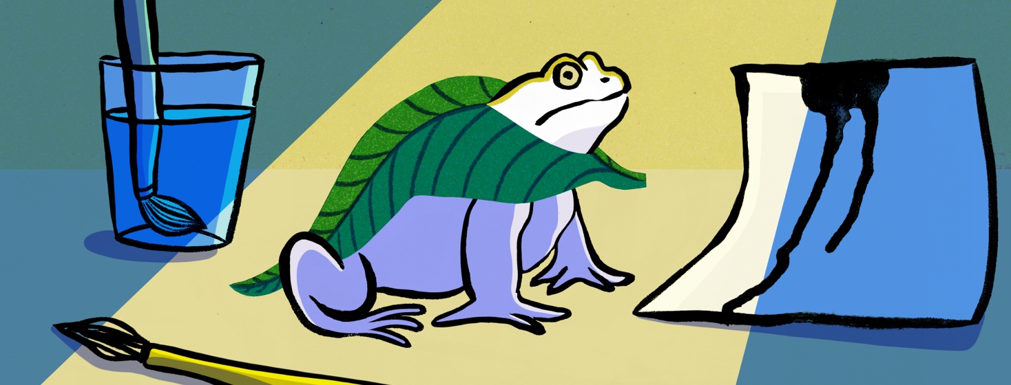 A Frog wearing a leaf cape sits near a paint brush paper and a glass of water